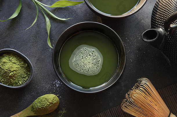 仪式上，传统的绿抹茶和竹子在黑桌子上搅拌。顶视图。文本的空间。