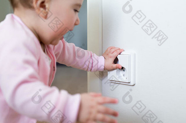 小孩在家触摸电源插座。儿童的安全。