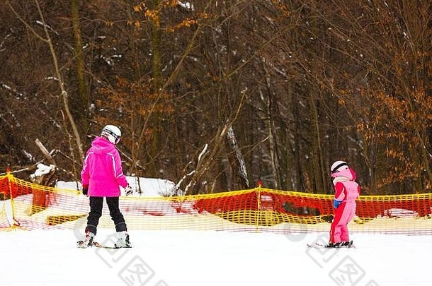 滑雪课，小女孩和教练一起滑雪