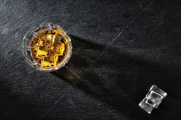 玻璃威士忌冰黑色的织构背景拍摄