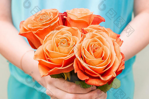 鲜花在女孩的手中。红<strong>玫瑰</strong>收拢了。一束美丽的花。节日背景