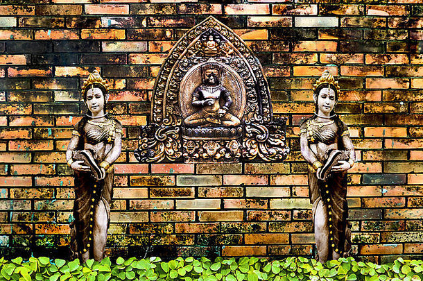 古雕双天使砖墙和绿色植物背景