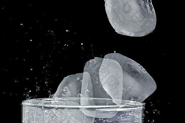 冰溅入一杯及时冻结的水的运动