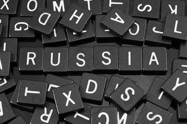 黑色字母瓷砖在反光背景上拼写单词“俄罗斯”