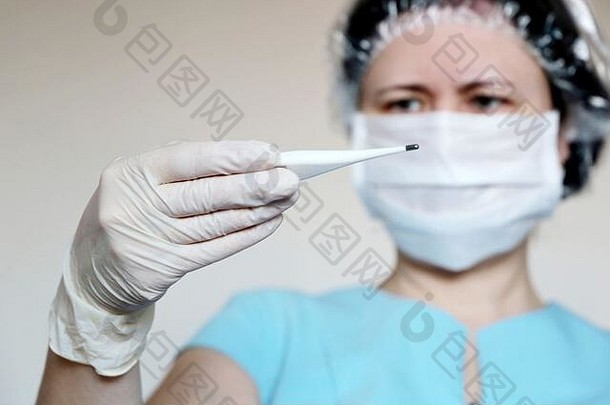 冠状病毒症状，戴医用面罩的妇女测量体温。医生看了看她手里的数字温度计，这是感冒和流感的概念