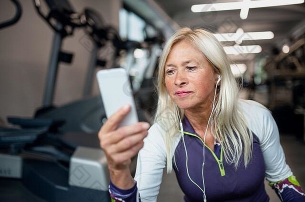 高级女人智能手机<strong>健身</strong>房休息锻炼