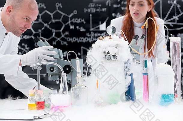 特写镜头老师化学实验室进行实验实验室工具色彩斑斓的液体气体学生obse
