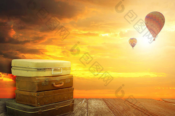 堆放皮革行李木板材热空气气球日落天空背景旅行概念旅程幻想自然背景