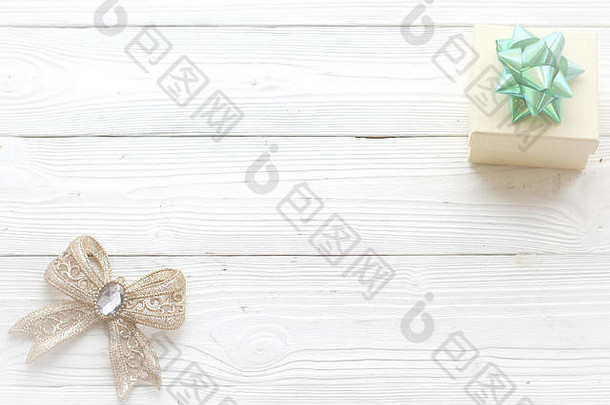 白色木质背景上的节日装饰、礼品盒和蝴蝶结