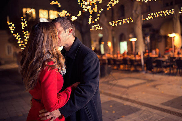 年轻的情侣在市中心接吻，新年和圣诞节。