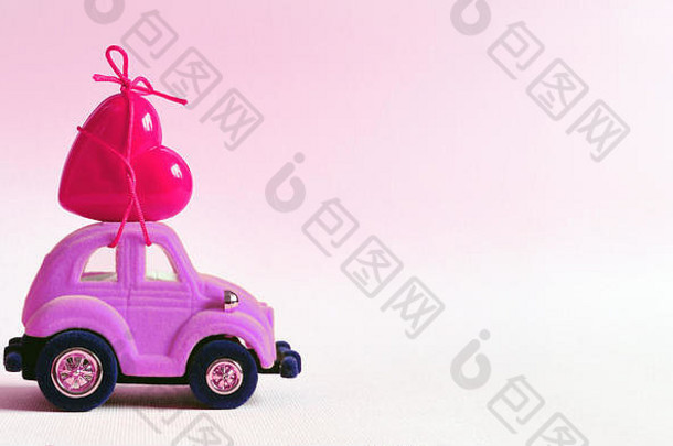 这辆粉红色的小车上有一颗红色的心。情人节的概念。