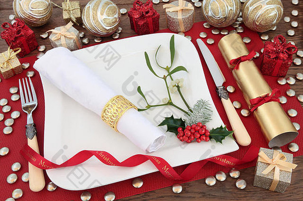 圣诞餐桌，白色瓷盘，亚麻餐巾，古董餐具，冬青树，槲寄生，装饰品。