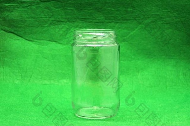 绿色背景上的玻璃空瓶，侧视图。库存照片，空白处用于文本和设计。