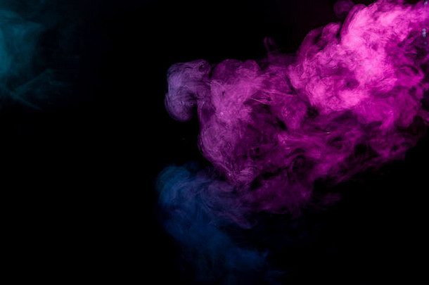 黑色隔离背景上的彩色粉色和蓝色烟雾。来自vape烟雾的背景