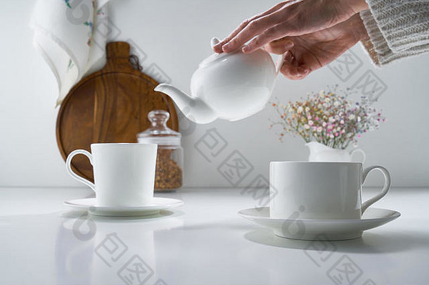 白色陶瓷茶具，浅灰色背景，带有精致的花束