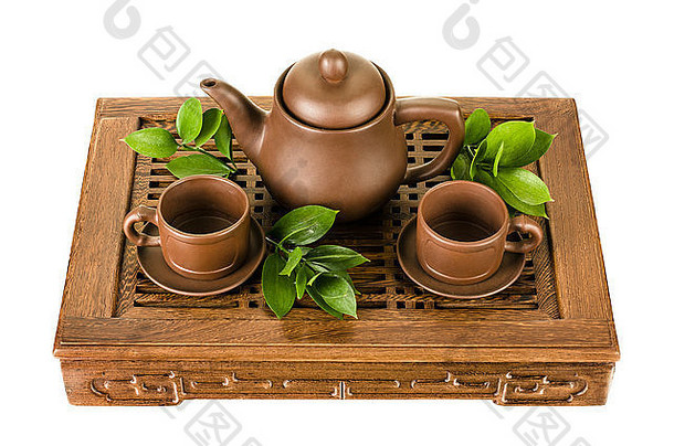 木制三角架上的陶制茶壶和茶杯的静物画，白色背景，与世隔绝