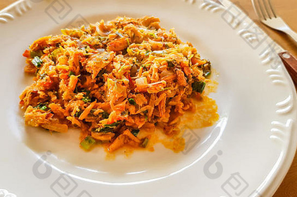 卡塔多·德·西里（Catado de siri）：巴西食物，蟹肉装在白色盘子里，木制背景上有刀叉