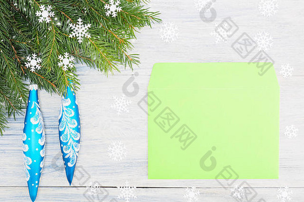 冷杉树枝，蓝色玩具，信封，白色木质背景上的雪花。圣诞节和新年概念