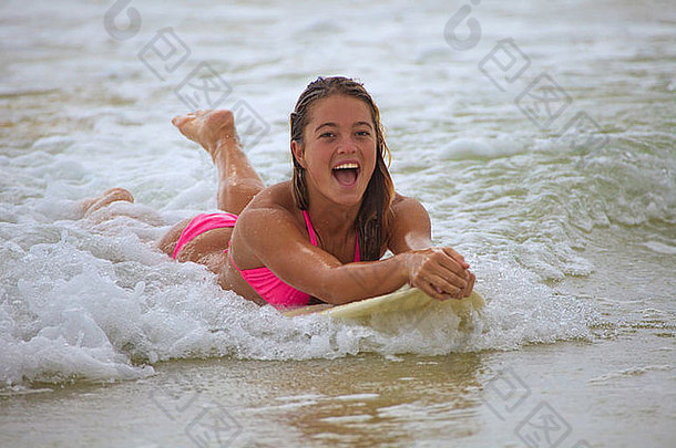 穿着粉色比基尼的少女在夏威夷冲浪