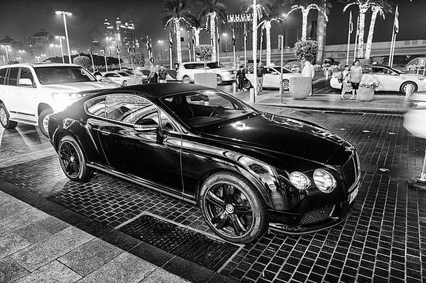 迪拜，阿联酋-2017年12月23日：豪华超级跑车Bentley continental gt e黑色停在迪拜购物中心旁。宾利是著名的高档汽车豪华品牌汽车