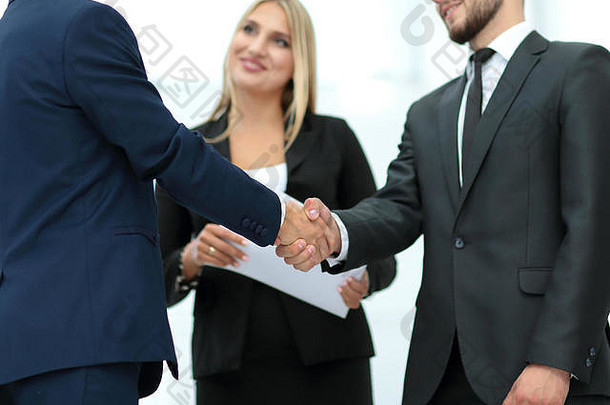 在一次<strong>招聘会</strong>之后，在一个办公室里握手以达成协议