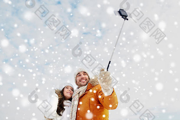 快乐夫妇采取自拍智能手机冬天