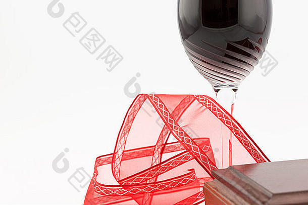 用红色丝带和木箱角旋转的干杯拍摄红<strong>酒</strong>的特写镜头。左边的空格。