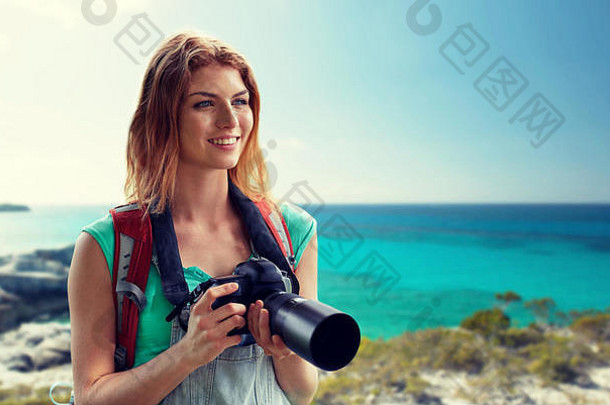 背着背包和相机在海边的快乐女人