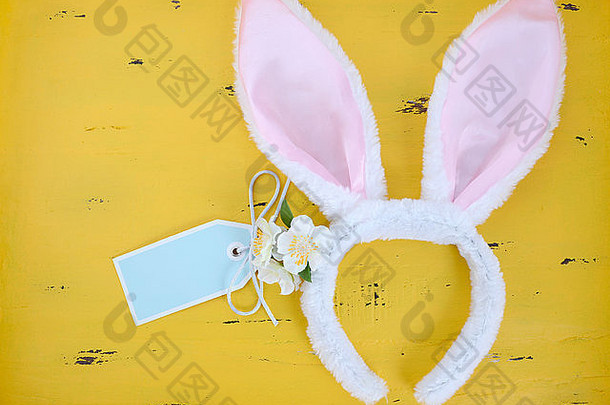 黄色木质背景，粉色和白色<strong>兔</strong>耳，复活节快乐。