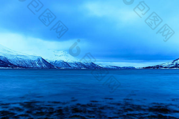 二月的一个早晨，蓝色的冬日之光。山地和海岸。斯特拉姆斯布克塔，克瓦利亚，特罗姆瑟，挪威。