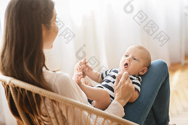 可爱的婴儿说谎母亲的腿上咕咕叫