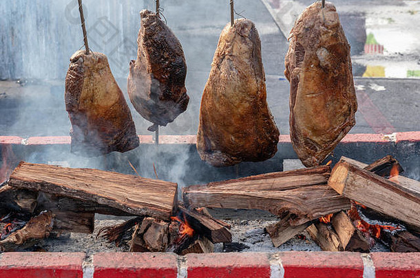 四大块肉放在一个带烟和火焰的木火上煮