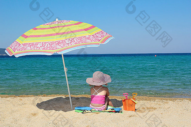 女孩坐着海滩遮阳伞