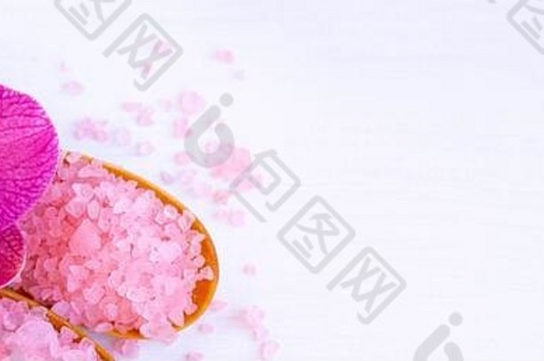 Banner Spa美容和美容治疗理念。粉色spa海盐、白色毛巾和紫色兰花，白色木质背景。平铺