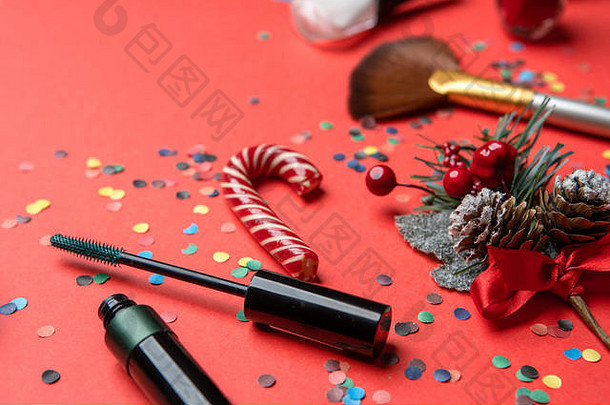 红色桌子上的画笔、五彩纸屑、圣诞装饰的图片