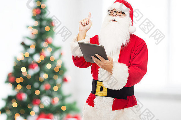 穿着圣诞老人服装的男人带着平板电脑