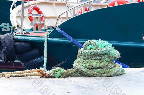 把绿色的航海绳卷在停泊的游艇的甲板上。