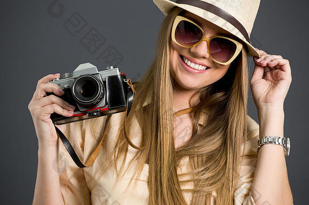 带着照相机和太阳镜微笑的旅游女孩