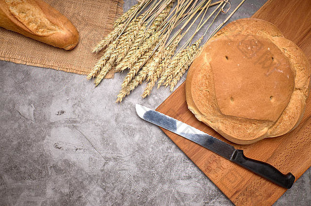 灰色背景上的乡村面包和小麦穗-健康食品概念