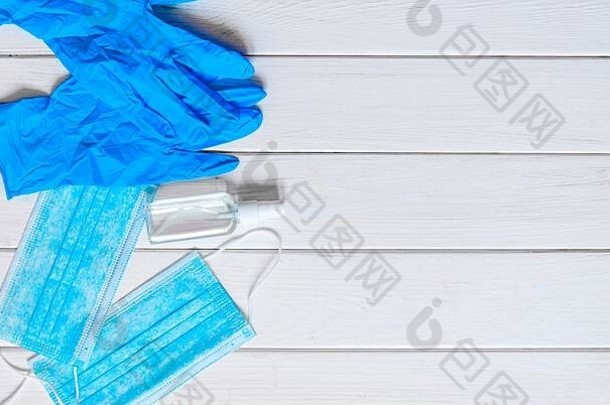 蓝色防护面罩、蓝色手套、抗菌喷剂和听诊器位于白色背景上
