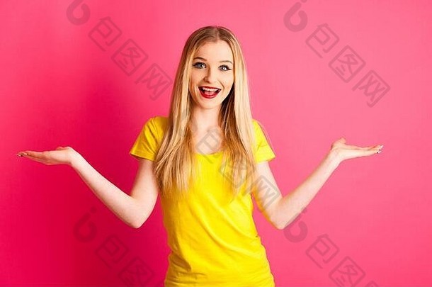 在粉红色背景上兴奋的年轻女子举起双臂表示成功