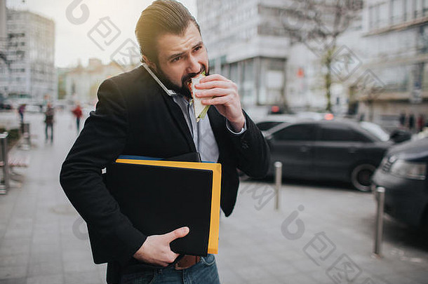 忙碌的人很匆忙，他没有时间，他正在路上吃零食。工人一边吃饭，一边喝咖啡，一边打电话