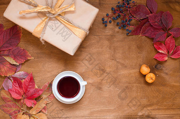 秋天在木制背景上留下一杯茶和咖啡作为礼物