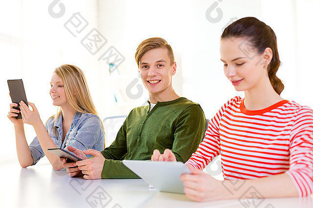 微笑的学生在学校使用平板电脑