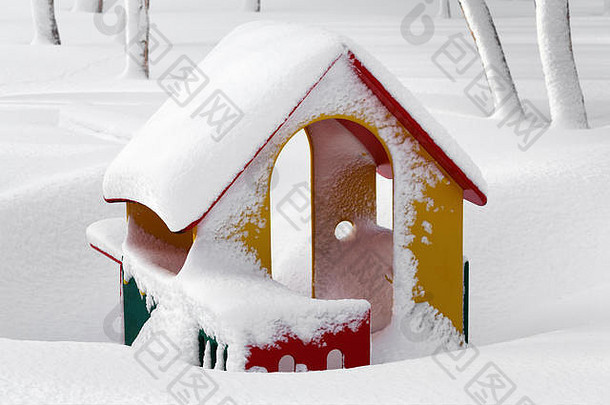 在暴风雪过后的冬季景观中，操场上有积雪覆盖的小<strong>红黄绿</strong>色儿童小屋。堪察加半岛堪察茨基市彼得罗巴甫洛夫斯克
