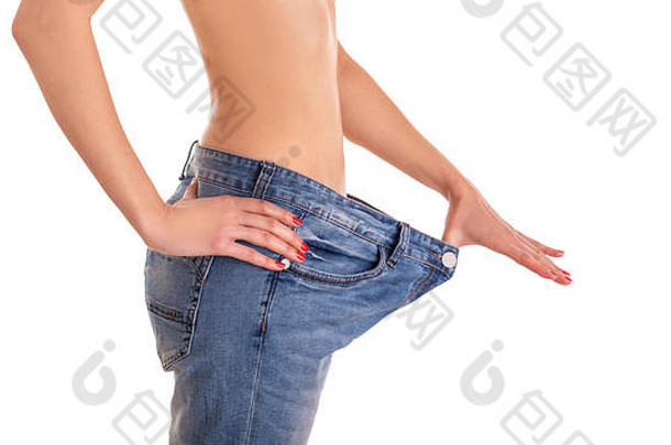 年轻的女人显示“瘦”数字拉大牛仔裤白色背景