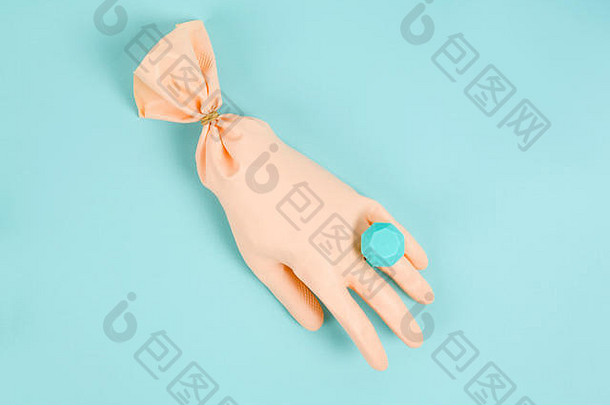 一种像气球一样膨胀的家用手套，戴着一个带有一颗钻石的塑料戒指