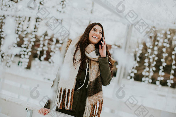 微笑年轻的女人电话公园冷冬天一天