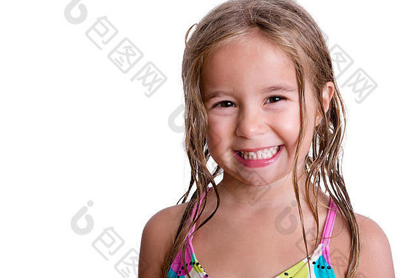特写镜头：一个快乐的小女孩，脸上挂着大大的可爱的微笑，白色背景下留着长长的金色湿发