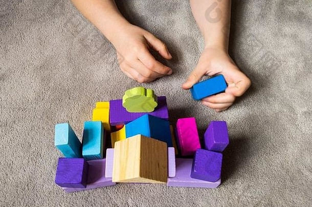 一个孩子正在用五颜六色的木制积木玩五颜六色的心。<strong>世界自闭症</strong>意识<strong>日</strong>概念。